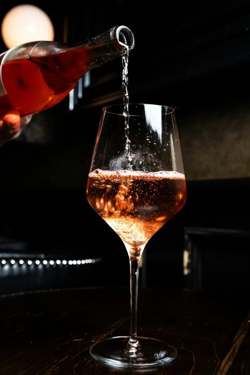 Vino rosato versato in un calice durante una degustazione