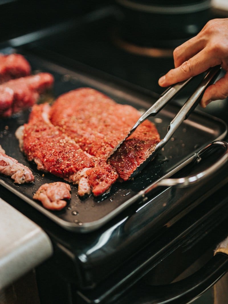 Bistecca di manzo condita pronta per la cottura alla piastra nella cucina del ristorante Le Contrade