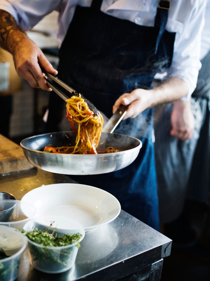 Chef del ristorante Le Contrade che impiatta della pasta appena saltata in padella